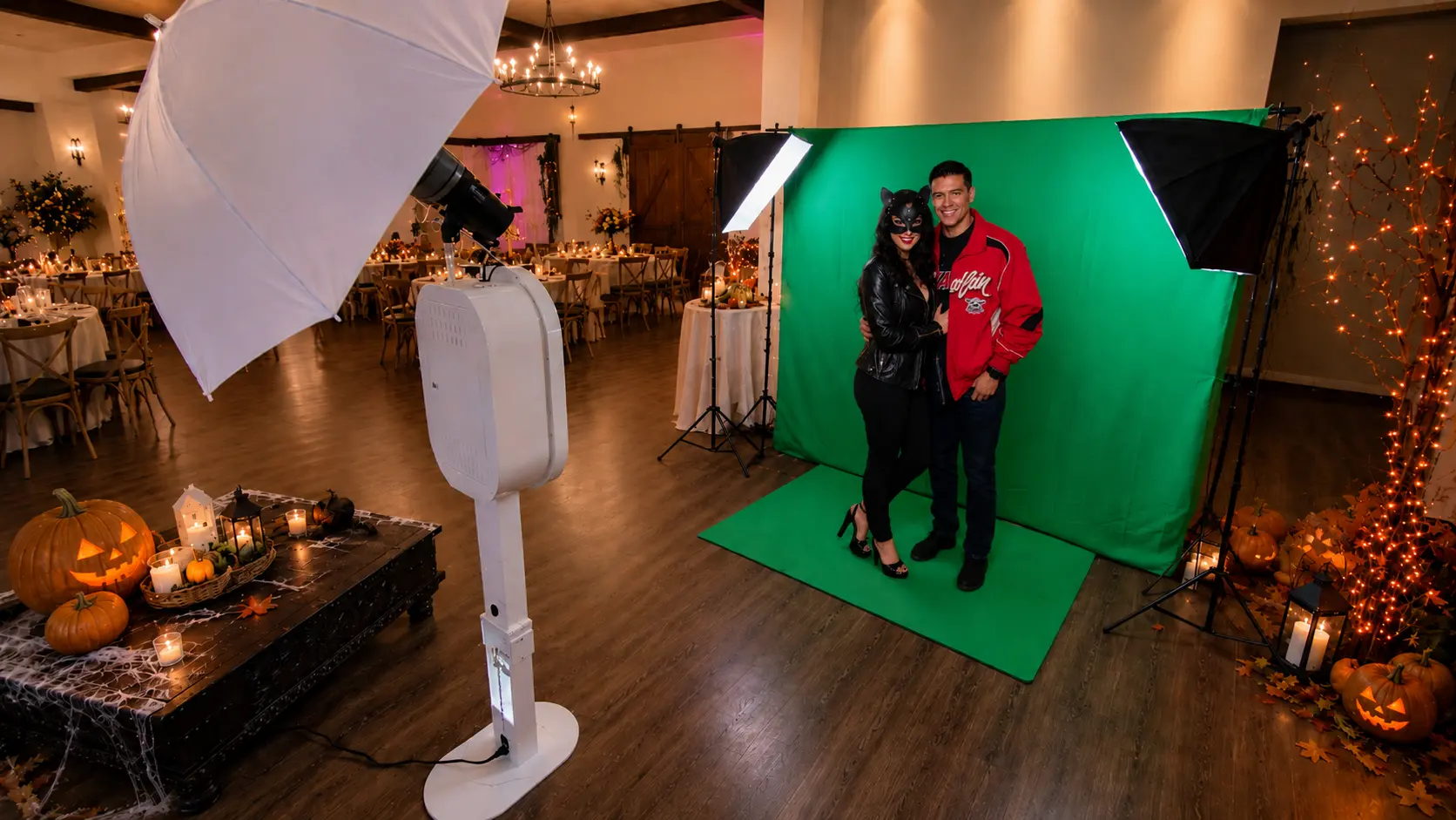 Halloween guests posing at an MnM green screen photo booth setup